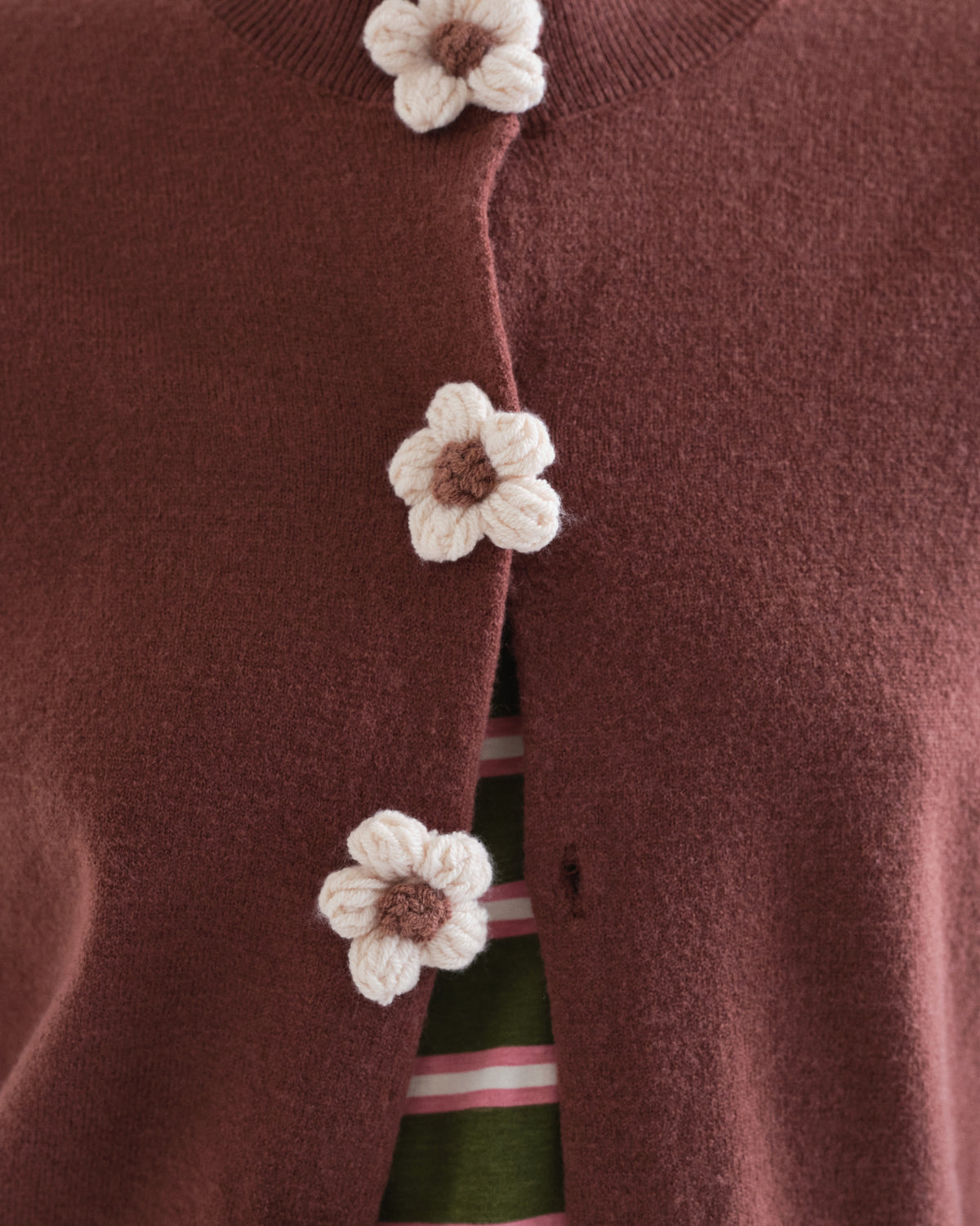 Détail des boutons en forme de fleurs du cardigan brun