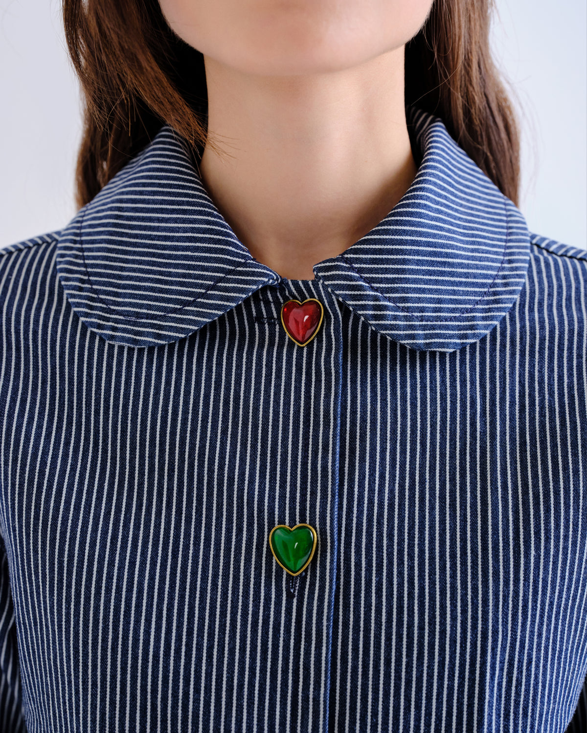 Détail des boutons cœur rouges et verts de la veste rayée Compañía Fantástica
