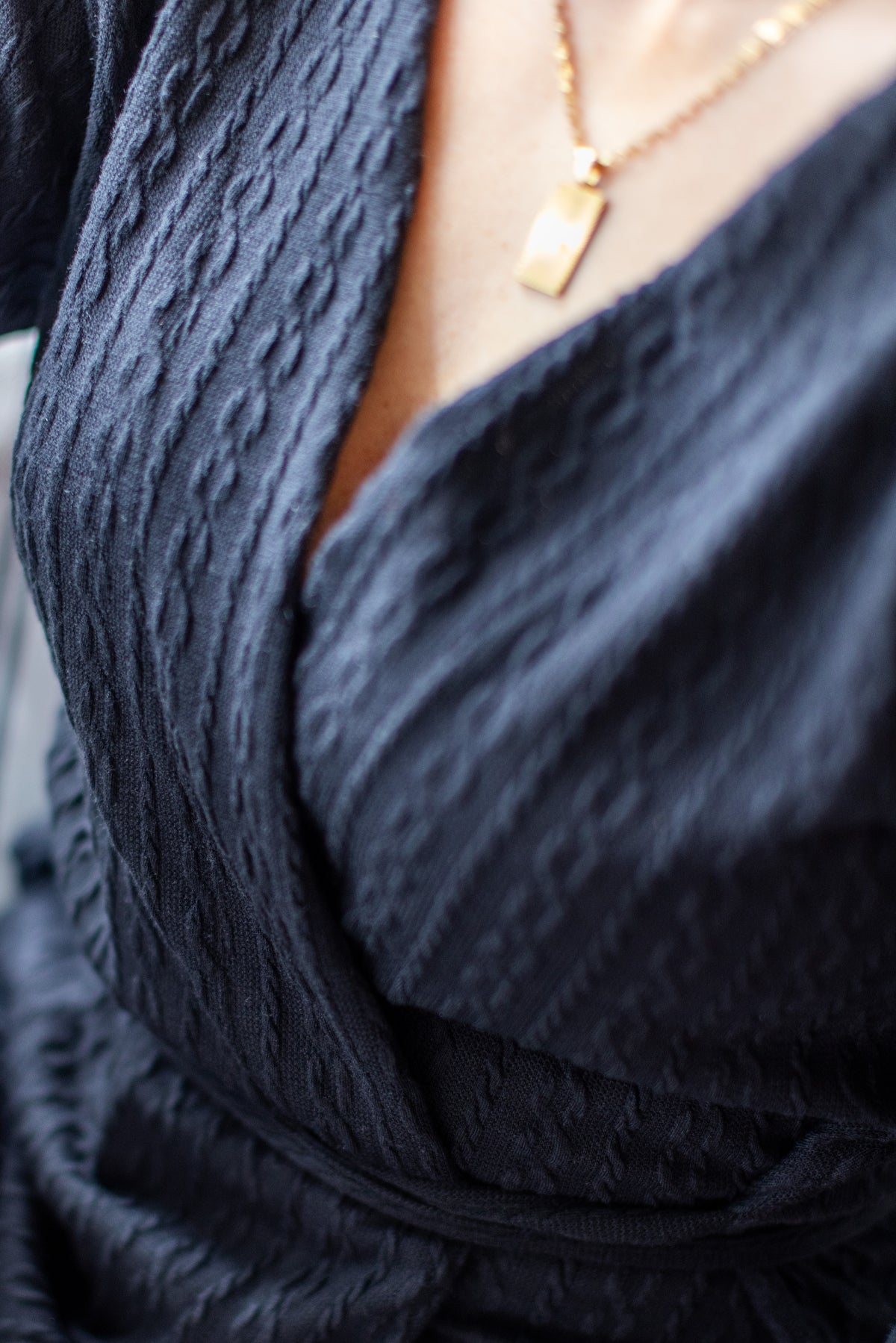 Cardigan noir à liens noués, détail de l’encolure cache-cœur